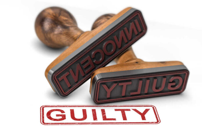 Two rubber stamps labeled guilty and innocent on a white surface