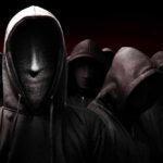 Faceless hooded figures standing in a dark background.