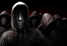 Faceless hooded figures standing in a dark background.