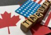 Wooden blocks spelling 'TARIFFS' on flags of Canada and the USA