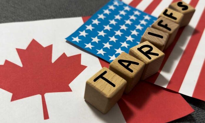 Wooden blocks spelling 'TARIFFS' on flags of Canada and the USA
