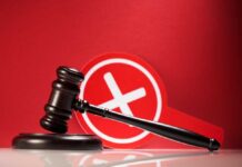 Judge's gavel with a red cross symbol in the background