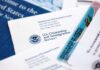 USCIS documents and a green card on a table