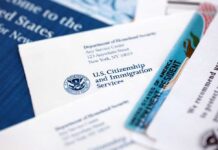 USCIS documents and a green card on a table