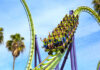 Roller coaster riders on a green and purple loop