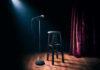 Empty stage with microphone and stool.