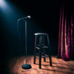 Empty stage with microphone and stool.