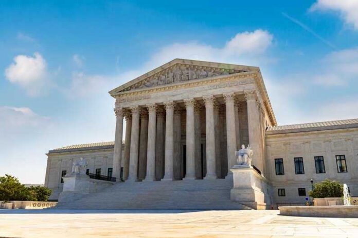 U.S. Supreme Court building exterior under blue sky.