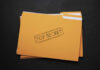 Yellow folder labeled Top Secret on black background.