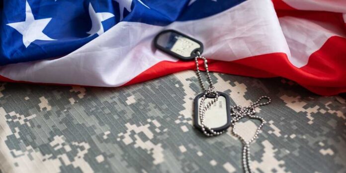 United,States,Flag,With,Camouflage,Military,Uniform,For,Independence,,Veterans, Military dog tags on camouflage fabric with an American flag