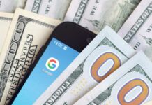 Smartphone with Google app on screen among US dollar bills