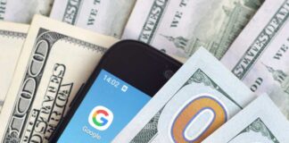 Smartphone with Google app on screen among US dollar bills