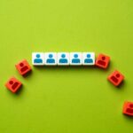 White and red cubes with person icons arranged in a semicircle on green background