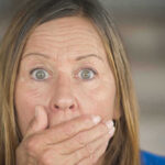 Surprised woman covering her mouth with hand.
