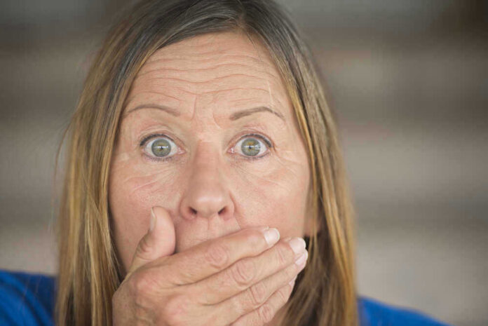 shutterstock_257978666 Surprised woman covering her mouth with hand.