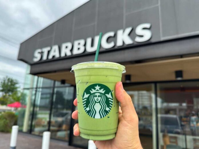 Bangkok,,Thailand,-,June,30,,2025:,Hand,Holding,Starbucks,Iced Hand holding a green matcha drink in front of a Starbucks store