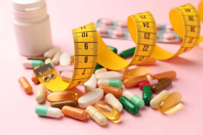 Different,Pills,,Measuring,Tape,,Blister,And,Medical,Bottle,On,Pink Assorted pills and a measuring tape on a pink background