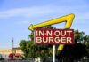 In-N-Out Burger sign with yellow arrow against blue sky