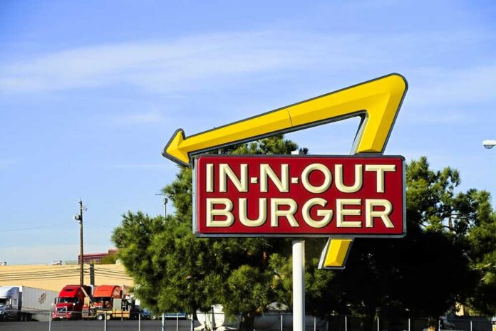 In-N-Out Burger sign with yellow arrow against blue sky