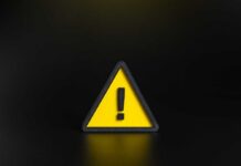 Yellow triangular warning sign with exclamation mark on black background