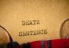 Typewriter typing the words death sentence on paper