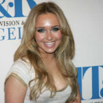 Smiling woman with long blonde hair at a media event