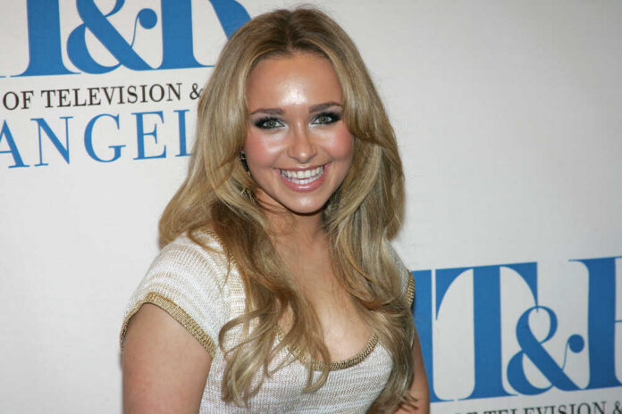 Smiling woman with long blonde hair at a media event