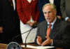 Greg Abbott speaking at a podium with a microphone