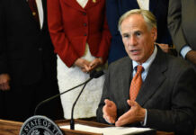 Greg Abbott speaking at a podium with a microphone