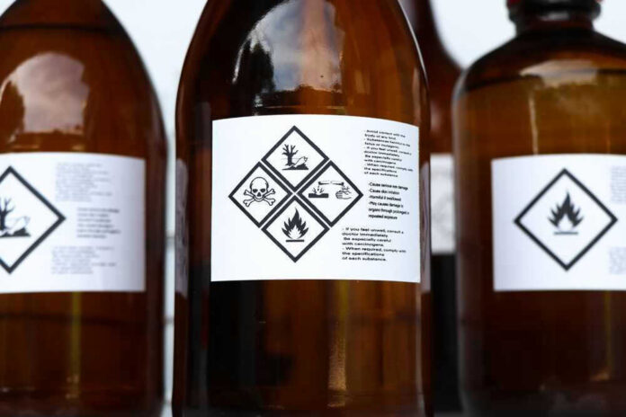 Brown bottles with hazard symbols and warning labels.