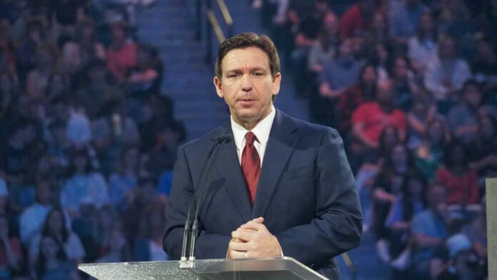 Ron DeSantis at a podium during an event; Christian Jones not visible
