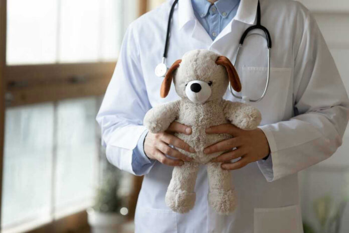 Doctor holding stuffed dog toy.