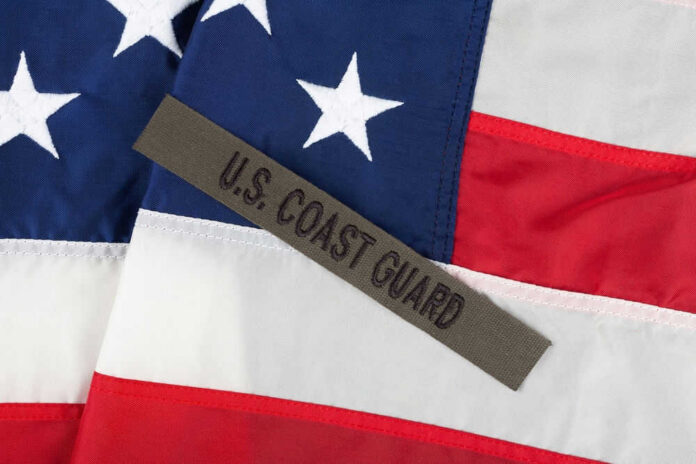 shutterstock_2492733653 U.S. Coast Guard patch on American flag.