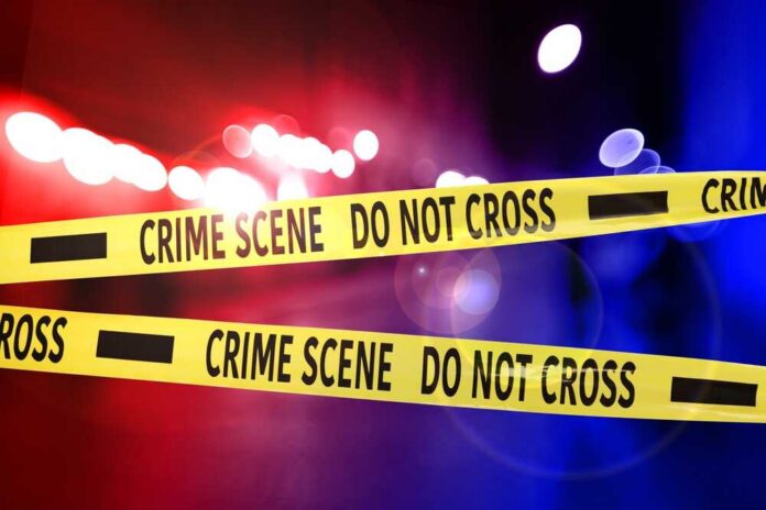 Crime scene tape with police lights in the background